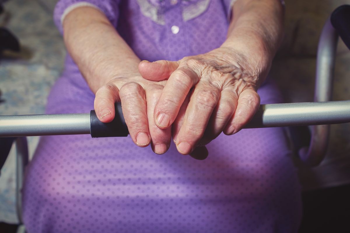 Hands of an elderly woman rests on on a walker. medical and healthcare concept.